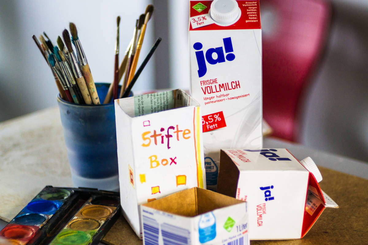 Malkasten und Pinsel; aus einem alten Tetrapack gebaute Stifte-Box