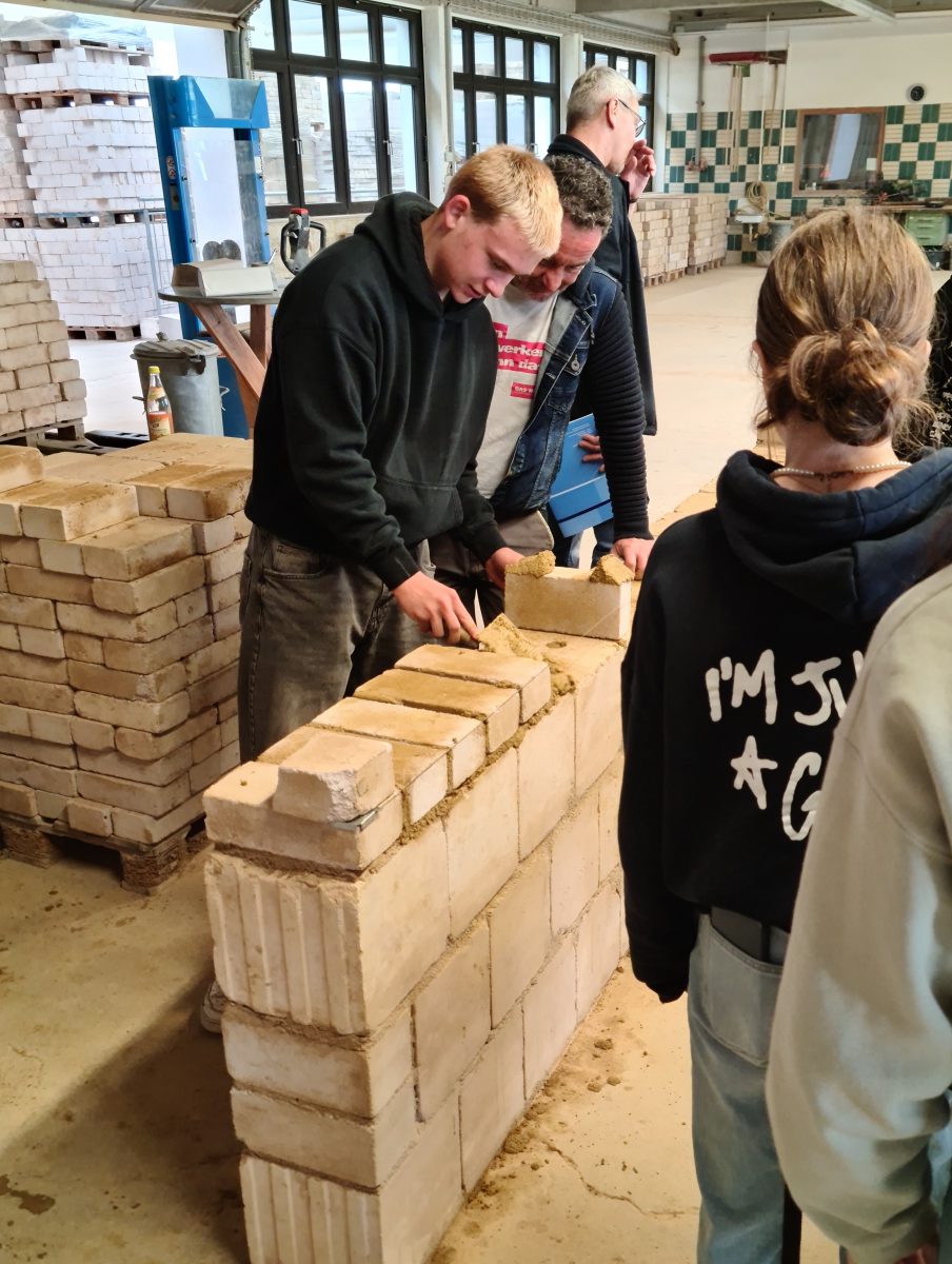Ein Schüler baut eine Mauer mit Mörtel