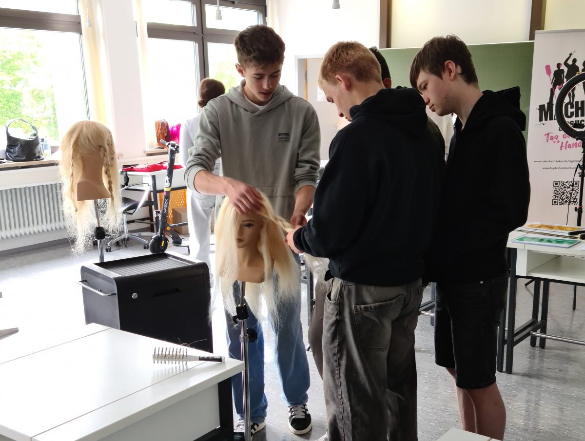 Schüler üben das Frisieren an einer Puppe