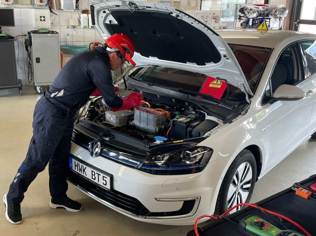Ein Mechaniker arbeitet am Motor eins Autos