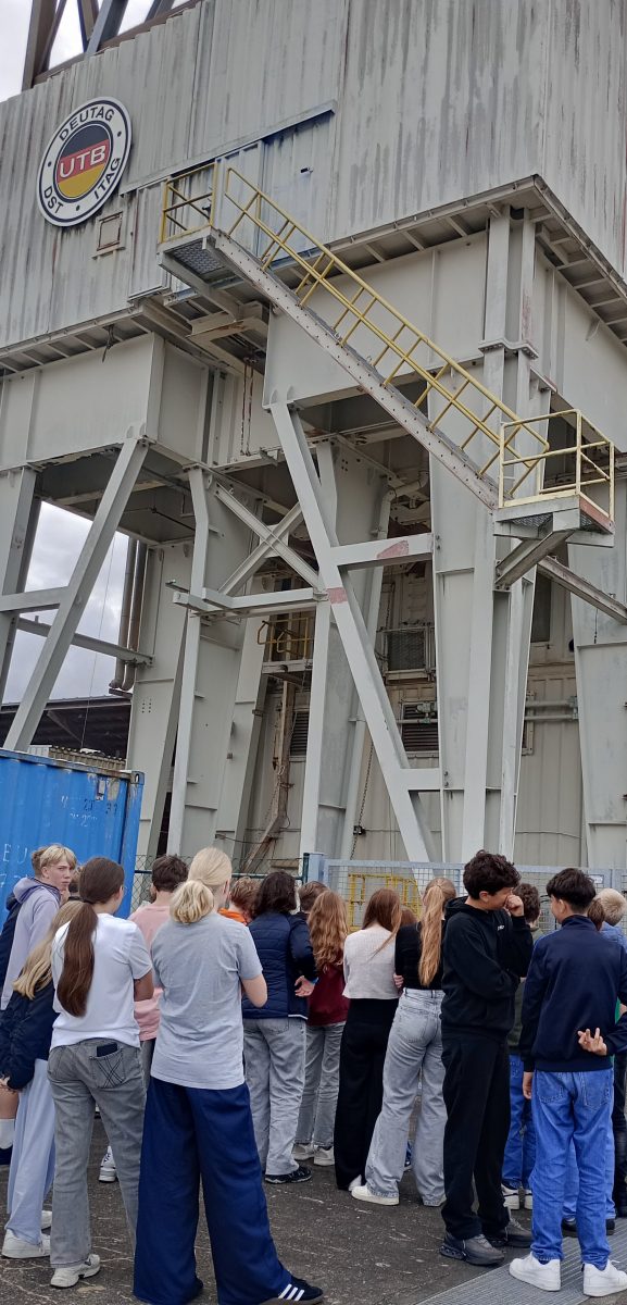 Eine Gruppe Schüler steht vor einem Bohrturm