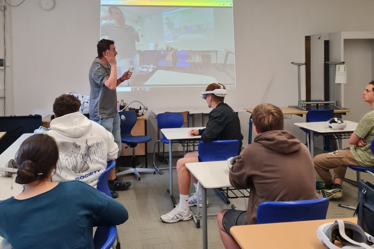 Schülerinnen und Schüler im Klassenzimmer lauschen dem Vortrag einer Lehrkraft