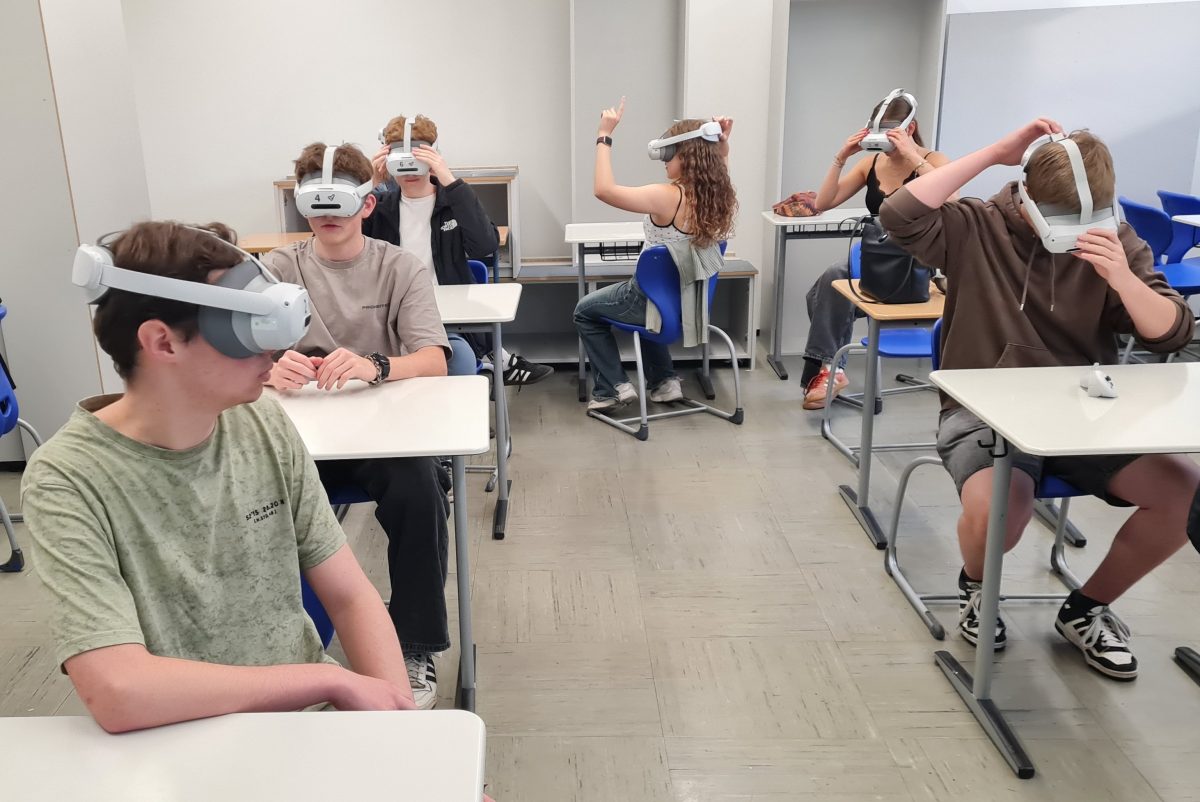 Schülerinnen und Schüler im Klassenzimmer tragen VR-Brillen