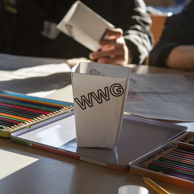 Auf einem Tisch steht ein Pappbecher mit "WWG"