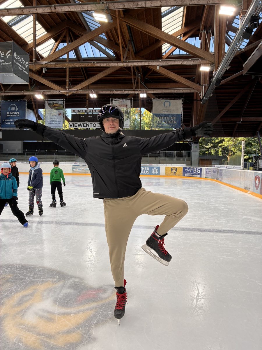 Eine Lehrkraft zeigt eine akrobatische Figur auf dem Eis