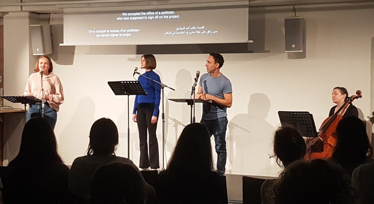 Drei Personen sprechen auf einer Bühne und eine Dame spielt Cello.