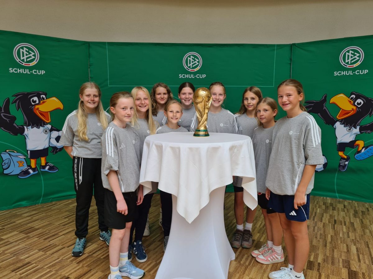 Das WWG-Mädchen-Team steht vor einem Tisch mit dem WM-Pokal