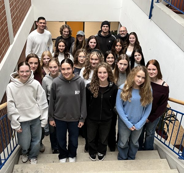 Die Mitglieder der SMV stehen auf einer Treppe im Schulhaus